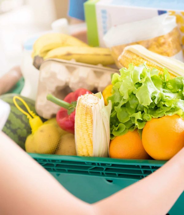 Delivery man delivering food to a woman - online grocery shopping service concept
